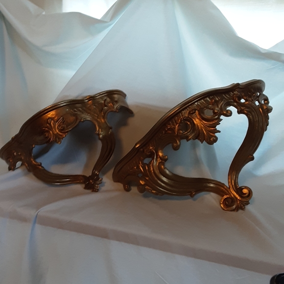 A pair of gold toned wall shelves